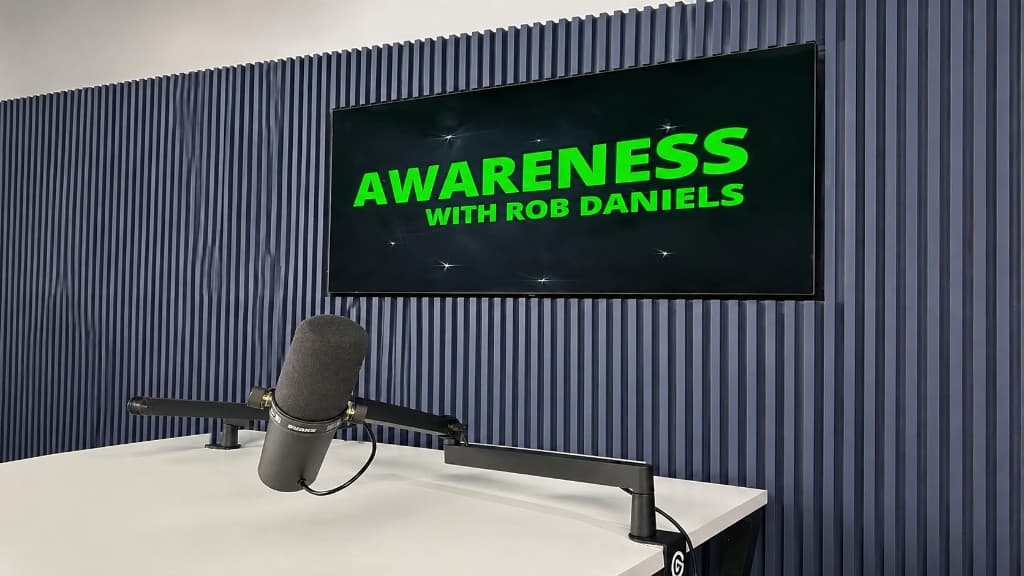 Awareness with Rob Daniels podcast studio with microphone and on-screen branding