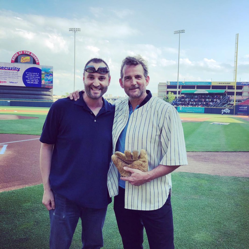 Radio personality Rob Daniels interviewing a guest at a baseball stadium live event